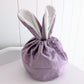 Purple velvet drawstring bag with bunny ears.