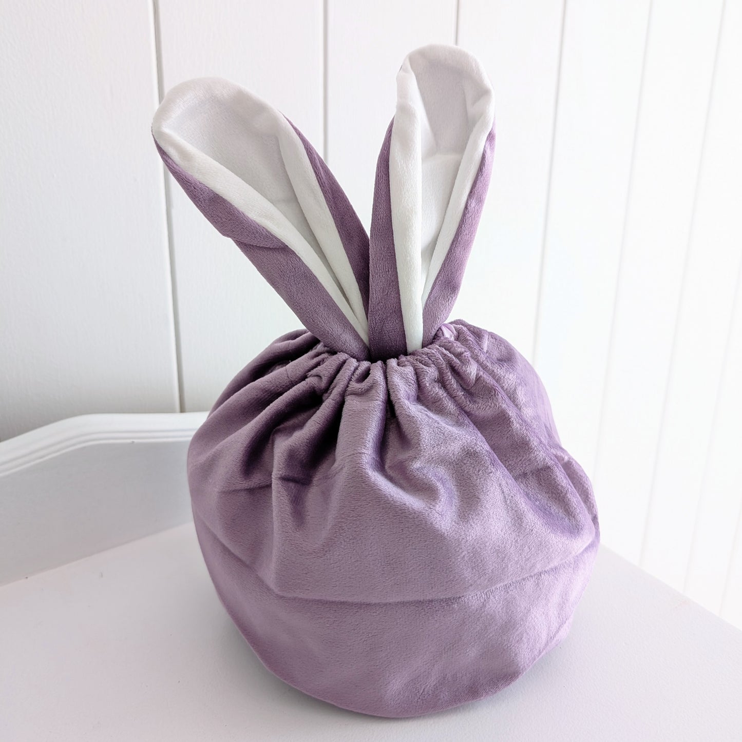 Purple velvet drawstring bag with bunny ears.