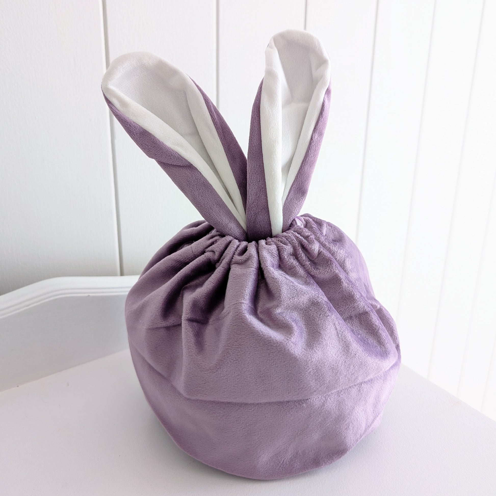 Purple velvet drawstring bag with bunny ears.