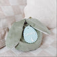 Green plush toy with a 'Sonny' tag on a checkered fabric background
