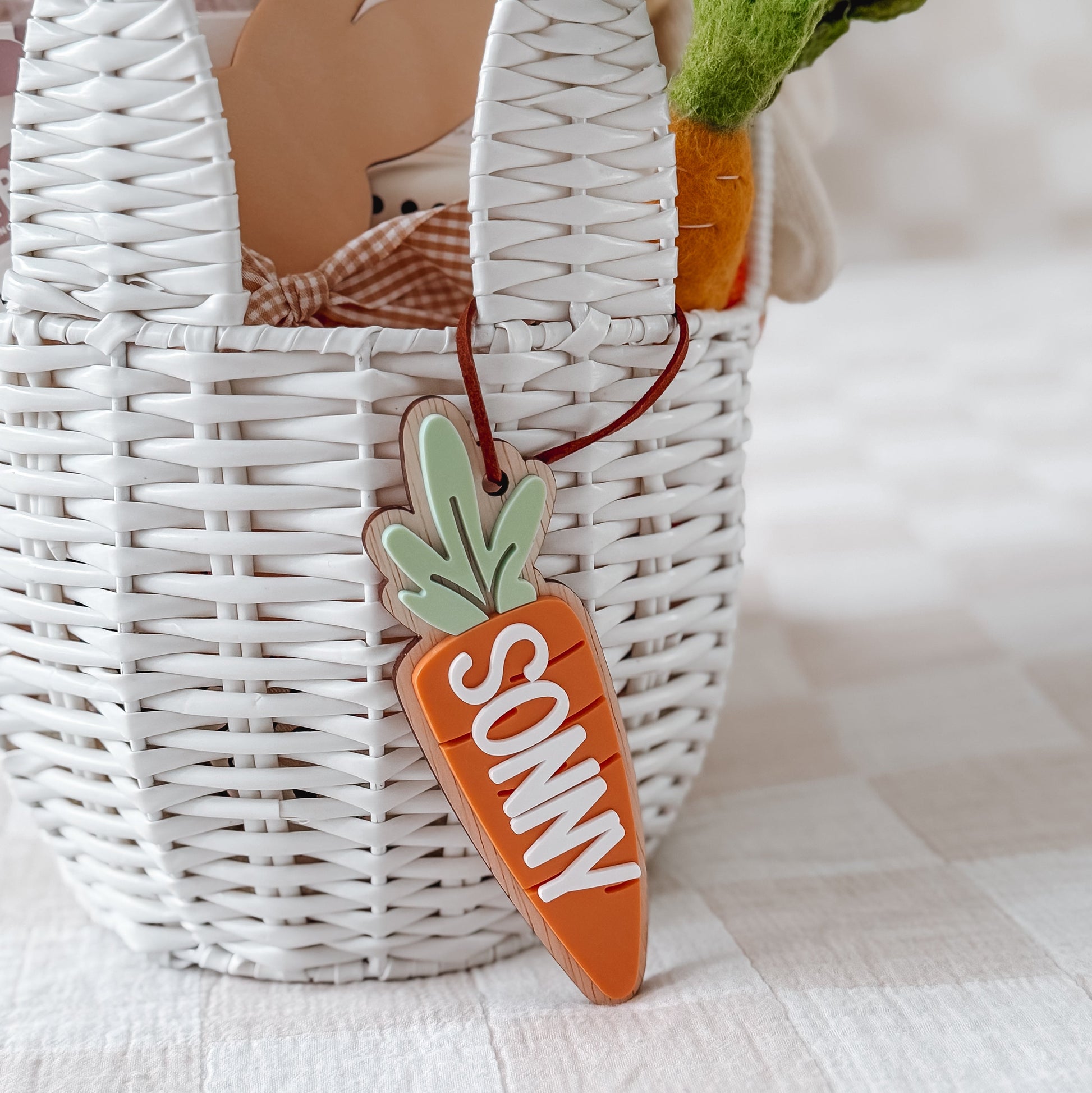 Carrot-shaped toy with 'SONNY' on it in front of a white basket.